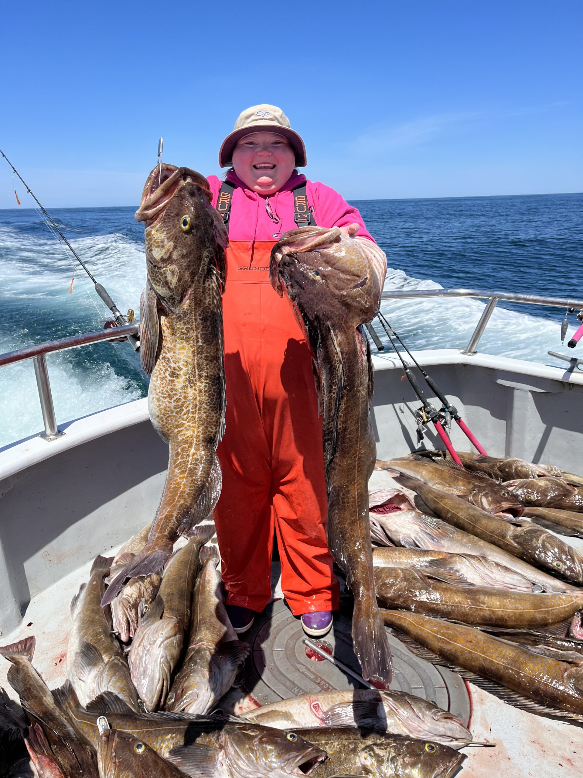 Morgan Northern holding two big lingcod over a deck full of fish