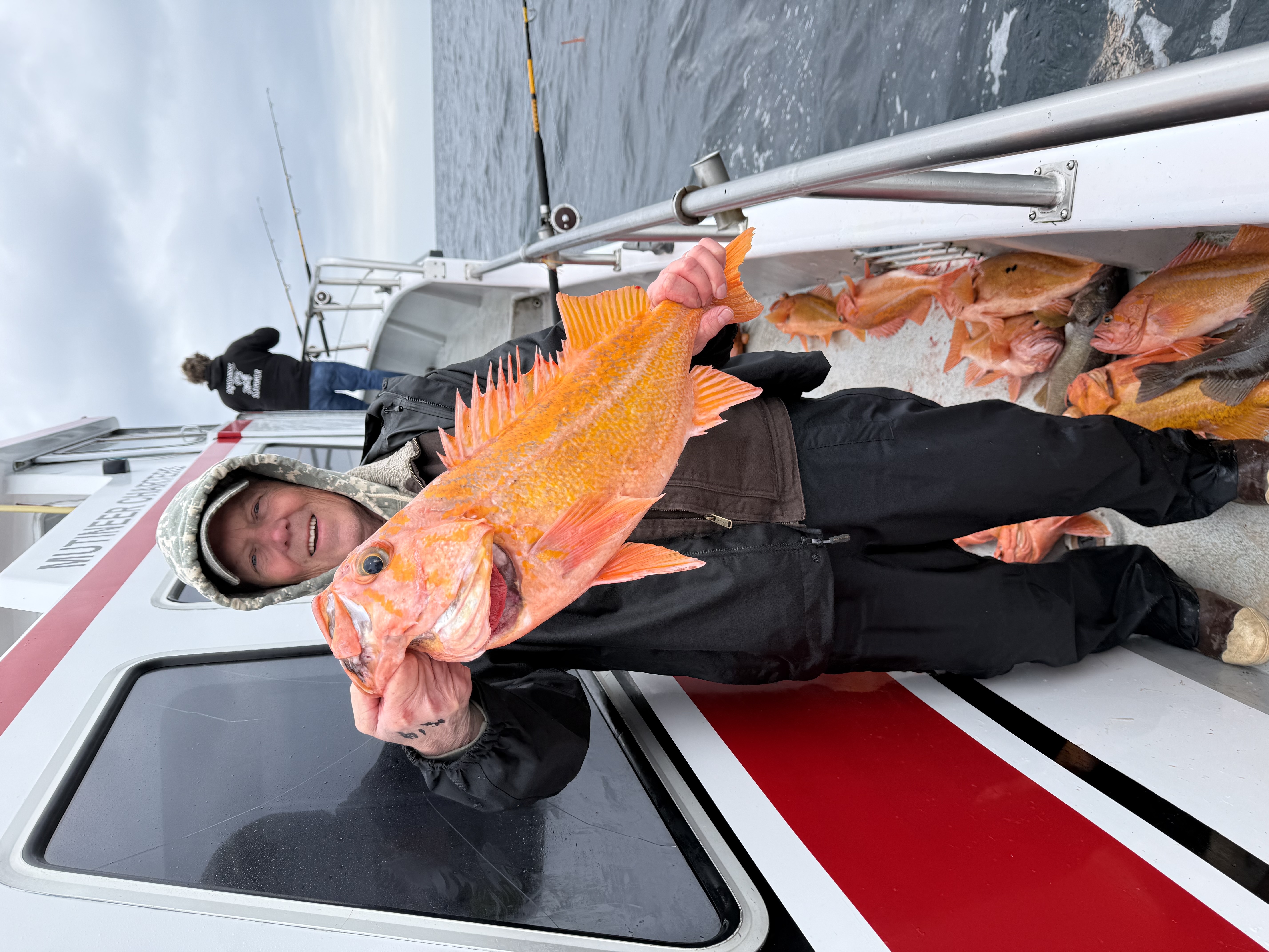 Dale McKenna holding a blazing orange rockfish