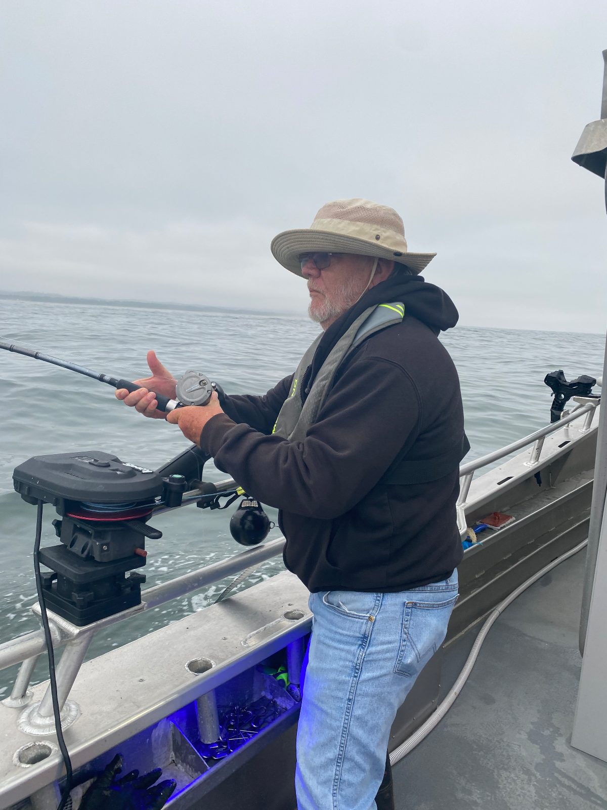 An angler fighting a fish over the rail of the Reel Electric