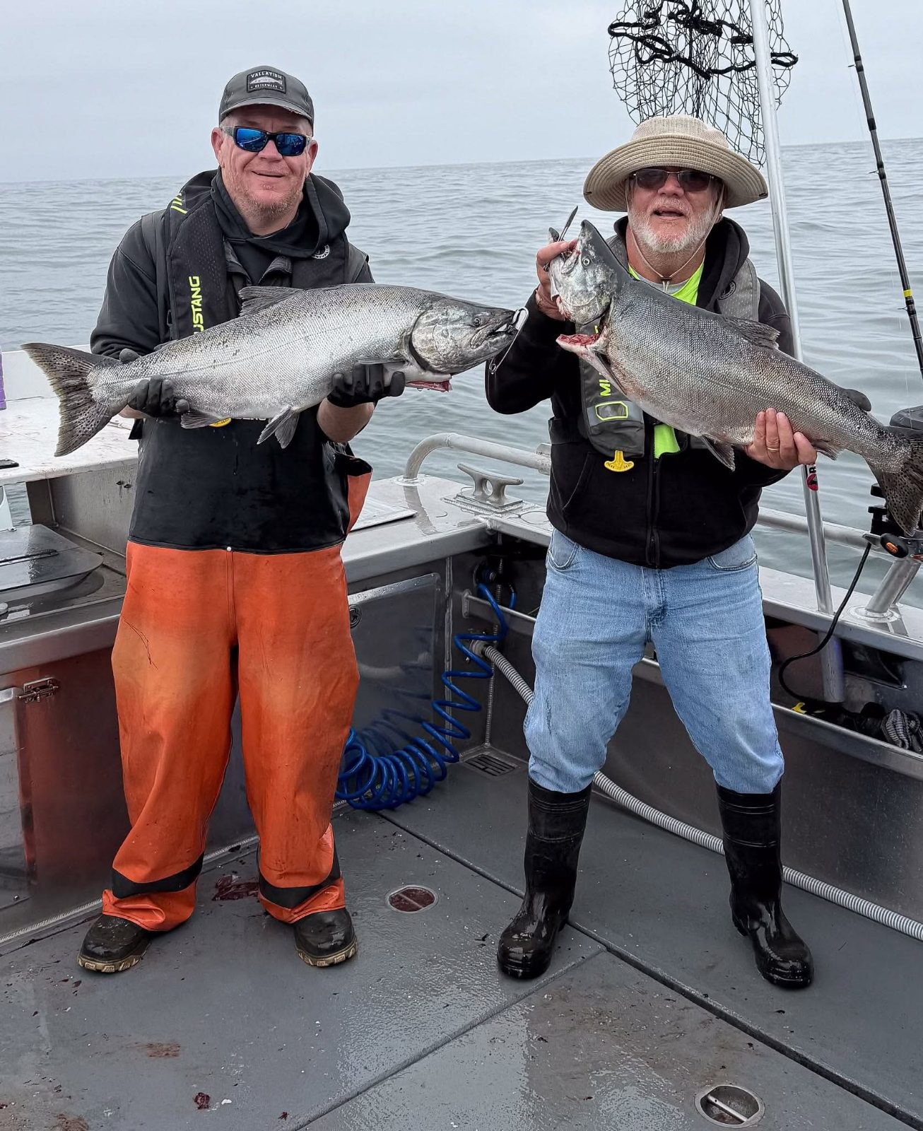 Merle Clayton and his fishing partner each holding a king salmon aboard the Reel Electric
